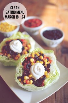 two lettuce wraps filled with toppings on top of a white platter