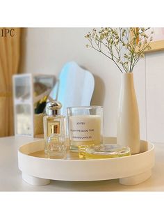 a white vase sitting on top of a table next to two glasses and a bottle