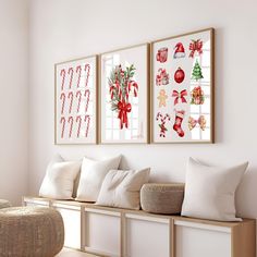 three framed pictures hang on the wall above a bench with white pillows and christmas decorations