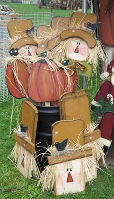 scarecrows made out of pumpkins and hay sitting on top of a barrel