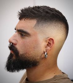 a close up of a man with a beard and earrings on his head, looking to the side