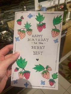 someone holding up a birthday card with strawberries on it