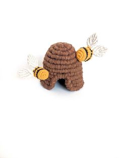 a crocheted bee with two white wings on it's head and one brown body