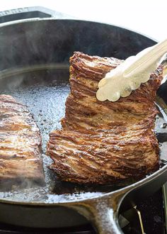 steak being cooked in a skillet on the stove