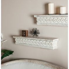 two white shelfs with candles on top of them