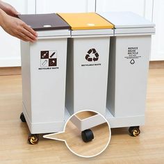 a person pushing a cart with two recycleable trash cans on it and another hand reaching for the garbage can