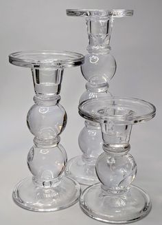 three clear glass candlesticks sitting on top of each other