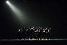 a group of people standing on top of a stage under a spotlight filled with bright lights