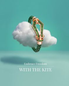 a green and gold ring sitting on top of a cloud with the words embrace freedom