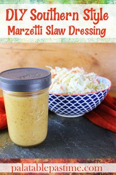 a glass jar filled with marzifi slaw dressing next to a bowl of coleslaw