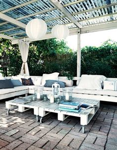 an outdoor living area with white furniture