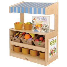 a wooden toy stand with baskets of fruit