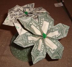 dollar bill origami flower sitting on top of a table