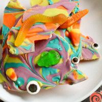 a white plate topped with colorfully decorated cookies and candies on top of each other