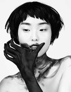 a woman with black paint on her face and hands