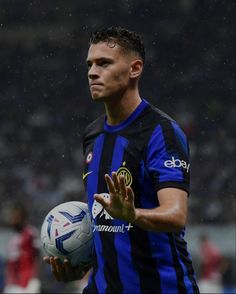 a man holding a soccer ball on top of a field