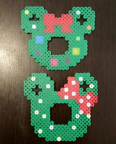 the letter c made out of perler beads on a wooden table with other items