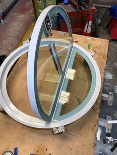 a large circular glass window sitting on top of a piece of wood next to other tools