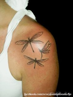 a woman with a dragon tattoo on her arm and shoulder, showing the three wings