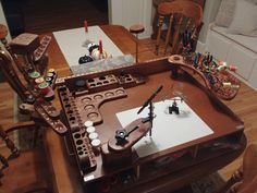 a wooden table topped with lots of crafting supplies on top of a hard wood floor