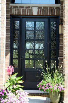 a black front door with two potted flowers