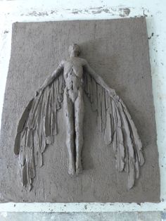 a sculpture of an angel with wings on the wall