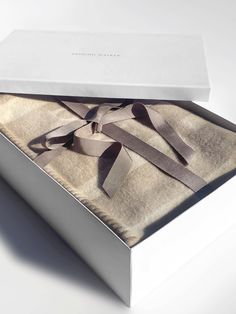 an open box with a ribbon tied around the inside of it on a white surface