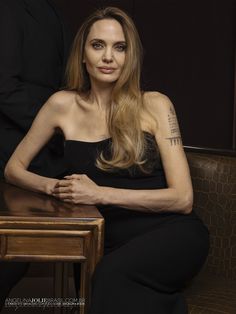 a woman sitting at a table with her arms crossed