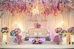 an elaborate stage decorated with flowers and chandelier for a wedding ceremony or reception