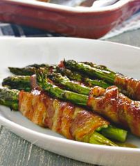 asparagus wrapped in bacon on a white plate