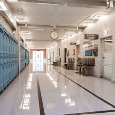 an empty hallway with lockers and a clock