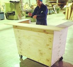 a man standing behind a wooden box in a warehouse