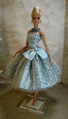 a barbie doll wearing a blue dress with silver sequins on it's skirt