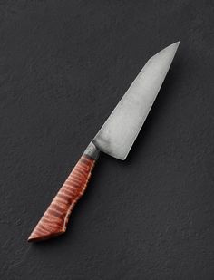 a knife with a wooden handle on a black surface