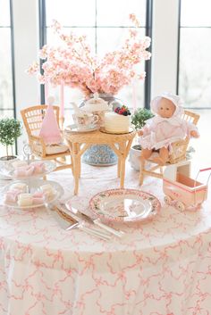 a table topped with a cake and doll figurines