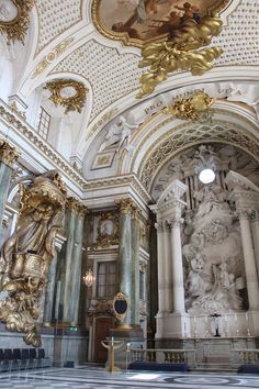 the interior of an ornate building with gold and white decor