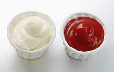 two small cups filled with ketchup and mayonnaise