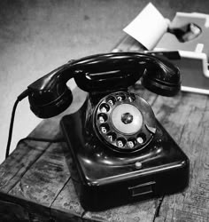 an old phone sitting on top of a wooden table