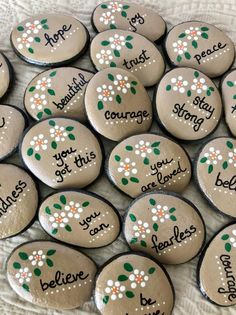 six painted rocks with names and flowers on them