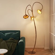 a living room with a green couch and a floor lamp in the shape of a flower