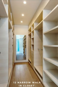 an empty walk - in closet with shelves and lights on the ceiling, along with wooden flooring