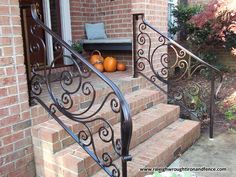 an iron stair rail with pumpkins on the steps