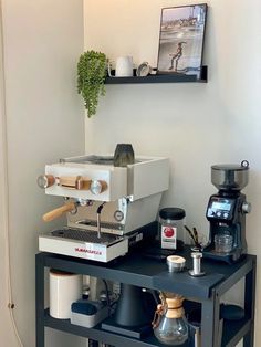 an espresso machine sitting on top of a table next to a coffee maker