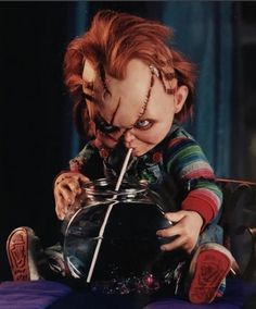 a creepy doll drinking out of a glass jar