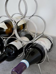 a bunch of wine bottles are stacked up in a rack on the floor next to each other