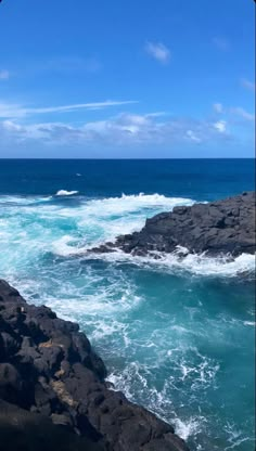 an ocean view with waves crashing on the rocks