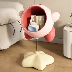 a pink and white object on a stand next to a bed