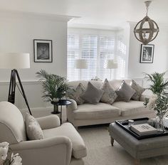 a living room filled with lots of furniture next to a window covered in shutters