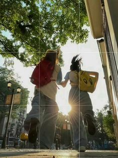 two people are walking down the street with their back to each other and holding hands