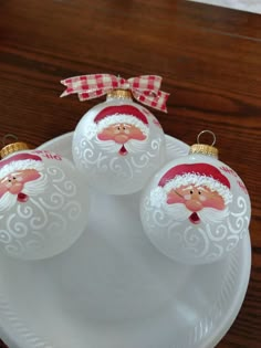 three glass christmas ornaments on a plate